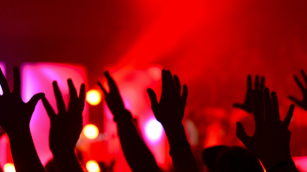 red glowing background audiences hands raised